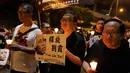 Massa menyalakan lilin dan membawa poster penerima Nobel Perdamaian, Liu Xiaobo, untuk mengenang kematian tokoh pro demokrasi itu di Hong Kong, Sabtu (15/7). Jasad Liu Xiaobo dikremasi, dan abunya dilarung ke laut, Sabtu ini. (AP Photo/Vincent Yu)