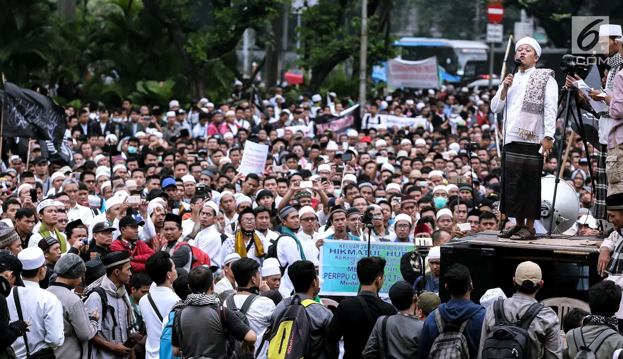 Seorang peserta aksi berorasi di depan ribuan massa yang tergabung dalam aliansi ormas dan umat Islam Jabodetabek menggelar aksi unjuk rasa di Pintu Barat Monas, Jakarta, Selasa (18/7). (Liputan6.com/Faizal Fanani)