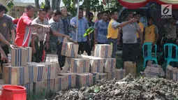 Polisi memusnahkan minuman keras (miras) di Polres Gorontalo, Gorontalo, Jumat (4/1). Miras yang dimusnahkan terdiri dari berbagai merek maupun tradisional. (Liputan6.com/Arfandi Ibrahim)