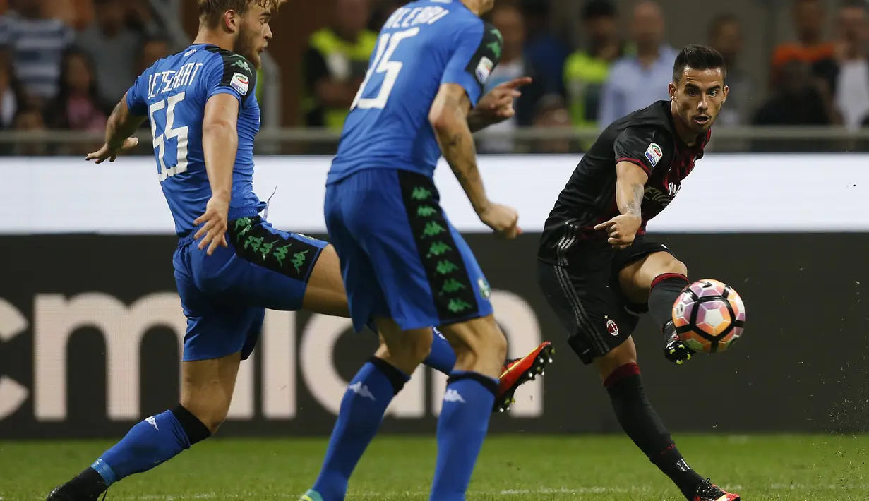 Gelandang AC Milan, Suso berusaha mengumpan bola dari kawalan dua pemain Sassuolo pada liga Italia di San Siro, Milan (3/9). AC Milan menang dramatis atas Sassuolo dengan skor 4-3. (AFP Photo/Marco Bertorello)
