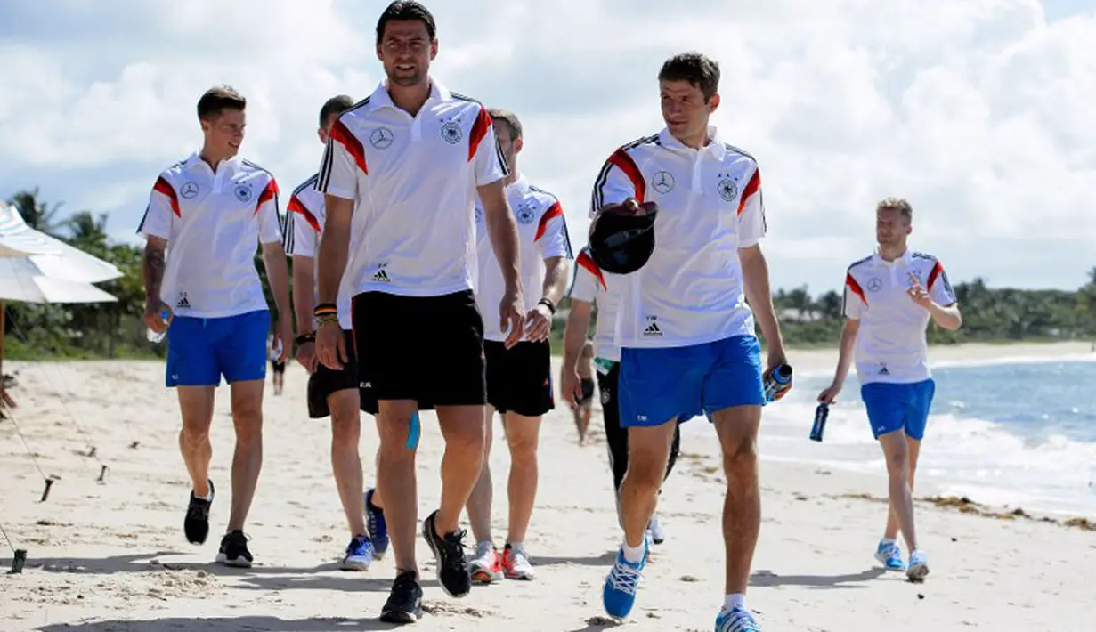 Penjaga gawang Timnas Jerman, Roman Weidenfeller (kedua dari kiir) bersama Thomas Mueller ikut berjalan-jalan di salah satu pantai dekat Santo Andre, Sao Paolo, Brasil, (10/6/2014). (AFP PHOTO/Markus Gilliar)