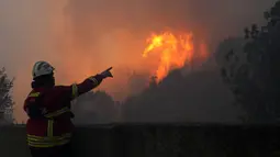 Dibantu oleh penduduk setempat, ratusan petugas pemadam kebakaran Portugal berjuang keras pada hari Selasa untuk memadamkan api yang melanda sebuah taman alam di dekat tujuan wisata populer Cascais, dengan angin kencang yang mempersulit upaya untuk mengatasi kobaran api. (AP Photo/Armando Franca)