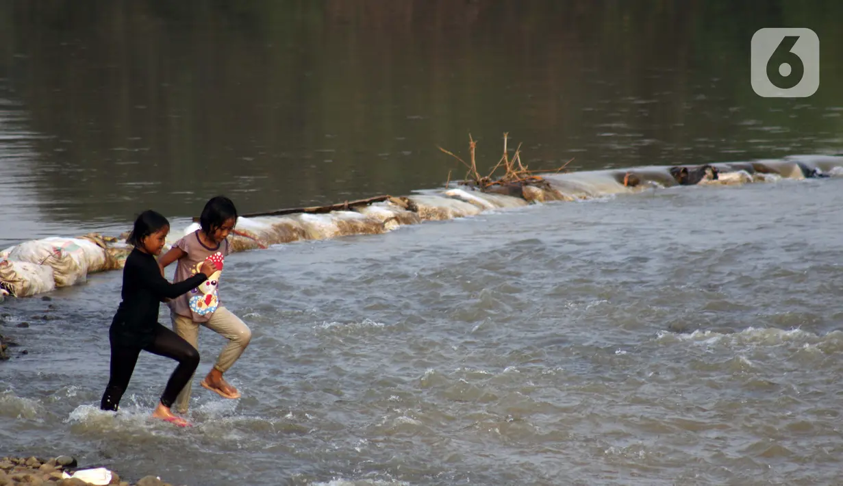 Anak-anak bermain air di area Bendungan Katulampa, Kota Bogor, Jawa Barat, Senin (3/8/2020). Debit air sungai Ciliwung di Bendung Katulampa yang mengalami penyusutan sejak satu bulan terakhir dimanfaatkan anak-anak untuk bermain air dan layangan. (Liputan6.com/Helmi Fithriansyah)