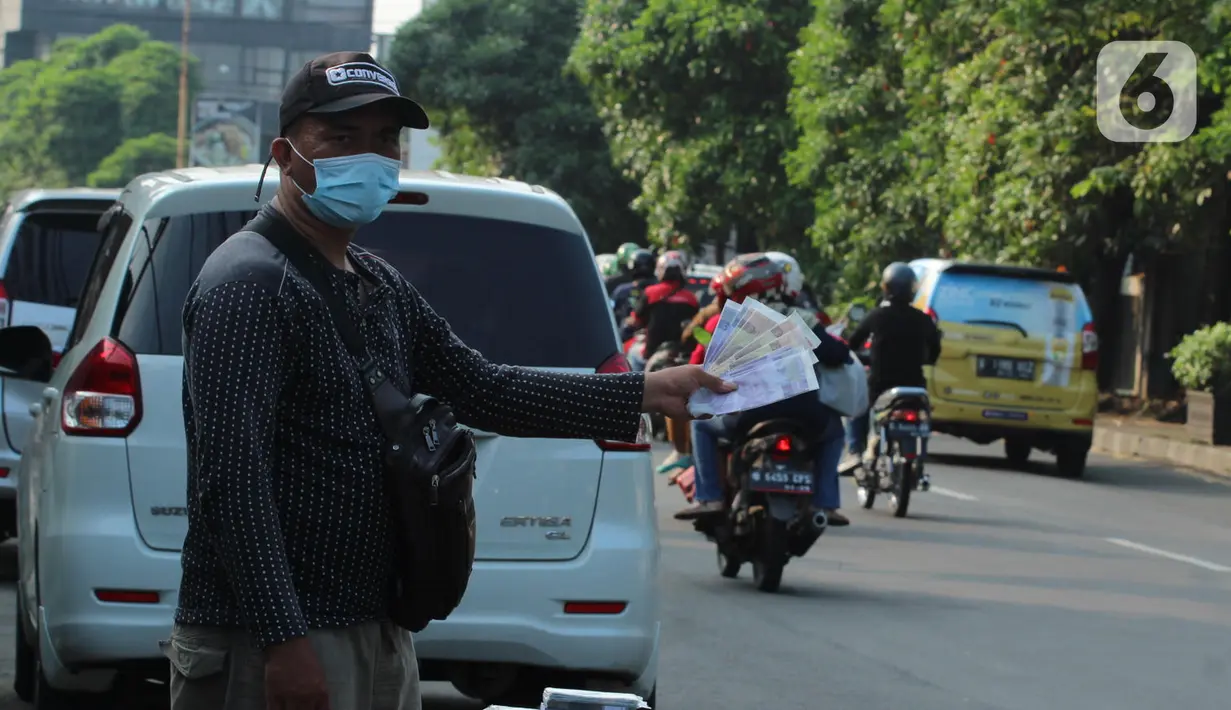 Penjual jasa penukaran uang baru menawarkan uang baru kepada pengguna Jalan Otista Raya di Karawaci, Kota Tangerang, Senin (10/5/2021). Penjual jasa penukaran uang baru musiman tersebut mulai bermunculan menjelang lebaran yang dikenakan tarif jasa sebesar 10 persen. (Liputan6.com/Angga Yuniar)