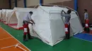 Petugas mendirikan tenda untuk orang-orang yang terlantar akibat banjir di aula olahraga di Provinsi Hormozgan di selatan Iran (4/1/2022). Sedikitnya dua orang tewas dalam banjir bandang di provinsi selatan Iran, Fars, kata seorang pejabat setempat. (AFP/Iranian Red Crescent)