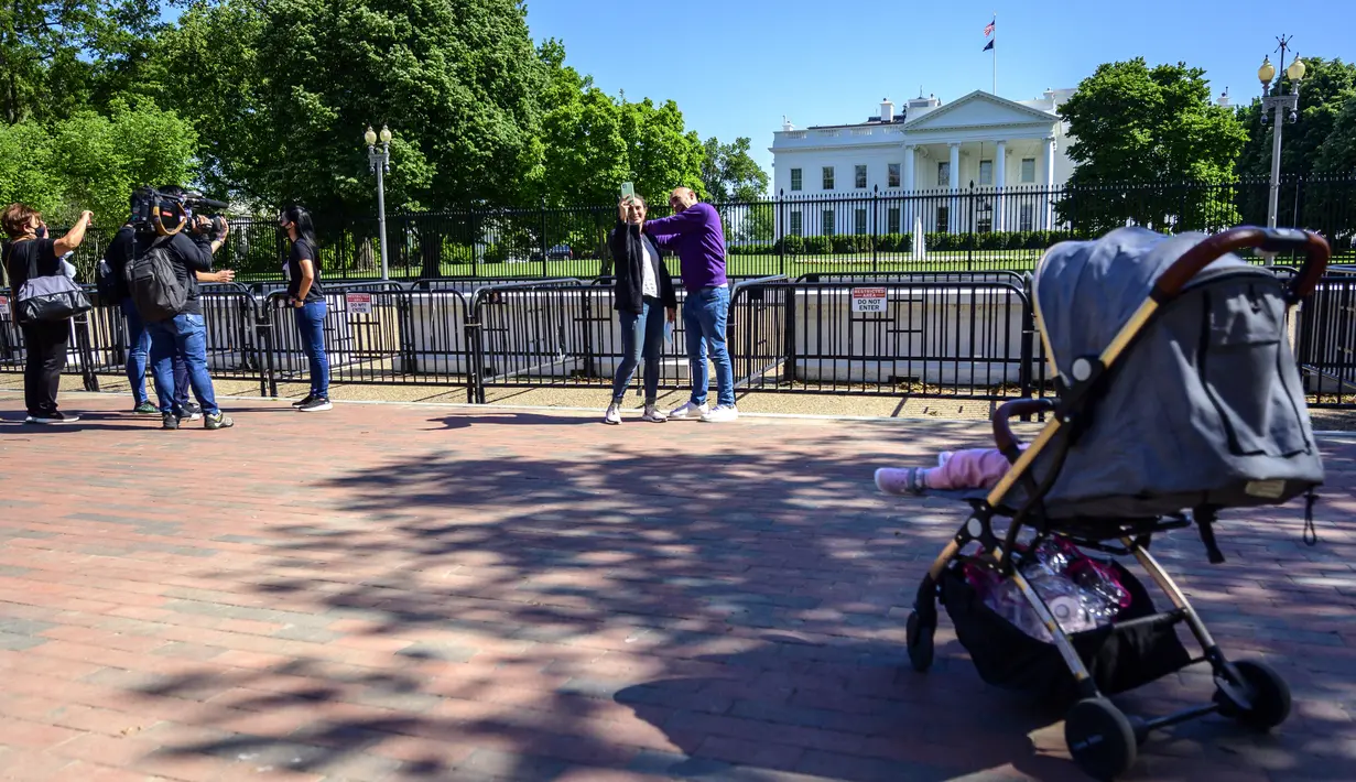 Turis dan warga mengunjungi Lafayette Square dekat Gedung Putih di Washington, DC, pada Selasa (10/5/2021). Lafayette Square dibuka kembali untuk pejalan kaki hampir setahun setelah daerah itu dipagari ketika demonstrasi semakin besar sebagai tanggapan atas kematian George Floyd. (Eric BARADAT/AFP)