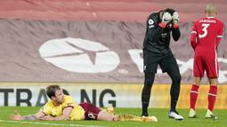Kiper Liverpool, Alisson Becker kecewa setelah aksinya menjatuhkan striker Burnley, Ashley Barnes diganjar hukuman tendangan penalti oleh wasit Mike Dean dalam laga lanjutan Liga Inggris 2020/21 di Anfield Stadium, Kamis (21/1/2021). Liverpool kalah 0-1 dari Burnley. (AFP/Jon Super/Pool)