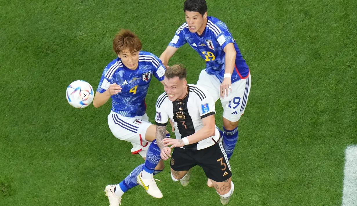 Bek Jerman, David Raum berebut bola dengan dua pemain Jepang Ko Itakura dan Hiroki Sakai selama pertandingan grup E Piala Dunia 2022 Qatar di Stadion Internasional Khalifa di Doha, Qatar, Rabu (23/11/2022). Dengan kemenangan ini, Jepang untuk sementara berada di puncak klasemen. (AP Photo/Petr Josek)
