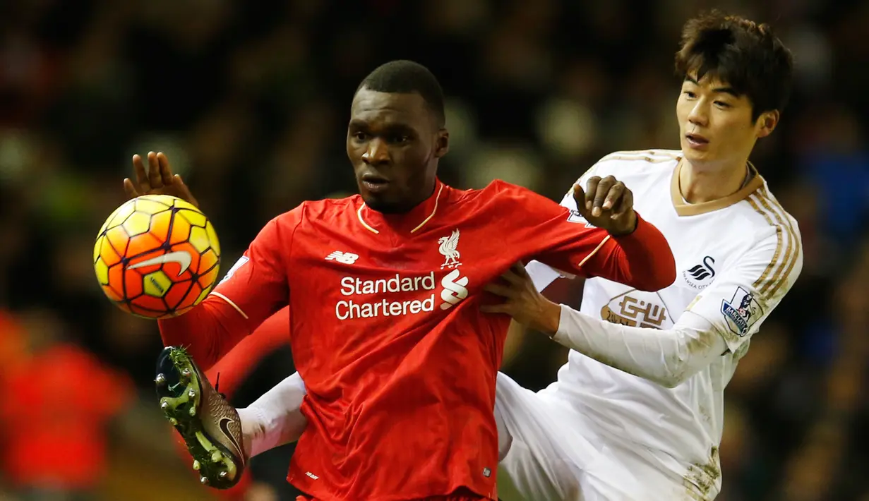 Penyerang Liverpool, Christian Benteke (depan) berusaha mengontrol bola dari kawalan gelandang Swansea, Ki Sung Yeung pada lanjutan liga inggris di Stadion Anfield, Inggris (29/11). Liverpool menang atas Swansea dengan skor 1-0. (Reuters/Phil Noble)