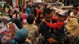 Warga memadati kawasan perbelanjaan Pasar Baru, Jakarta, Minggu (26/6). Menjelang lebaran sejumlah toko mulai memberikan potongan harga untuk menarik pembeli. (Liputan6.com/Gempur M Surya)