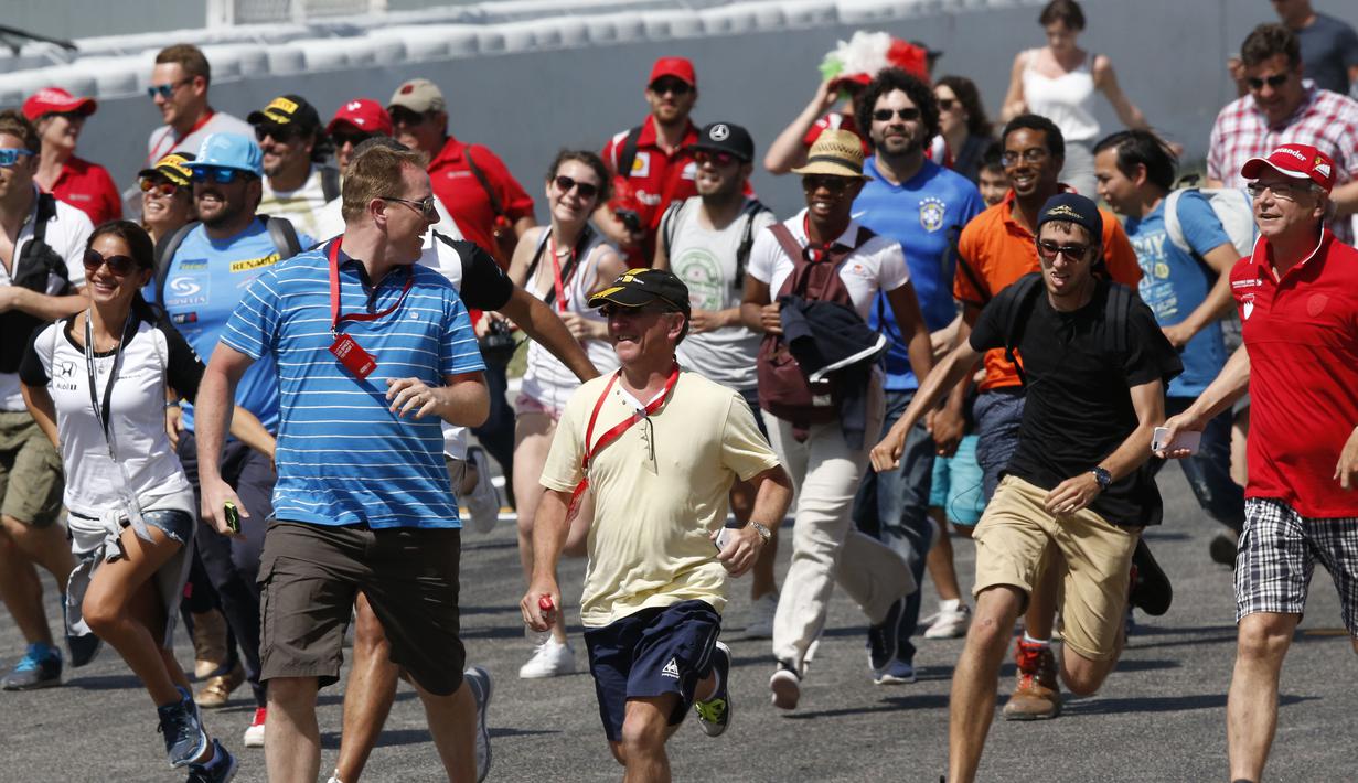 Para fan berlari mendekati area podium. (Reuters/Gustau Nacarino) 