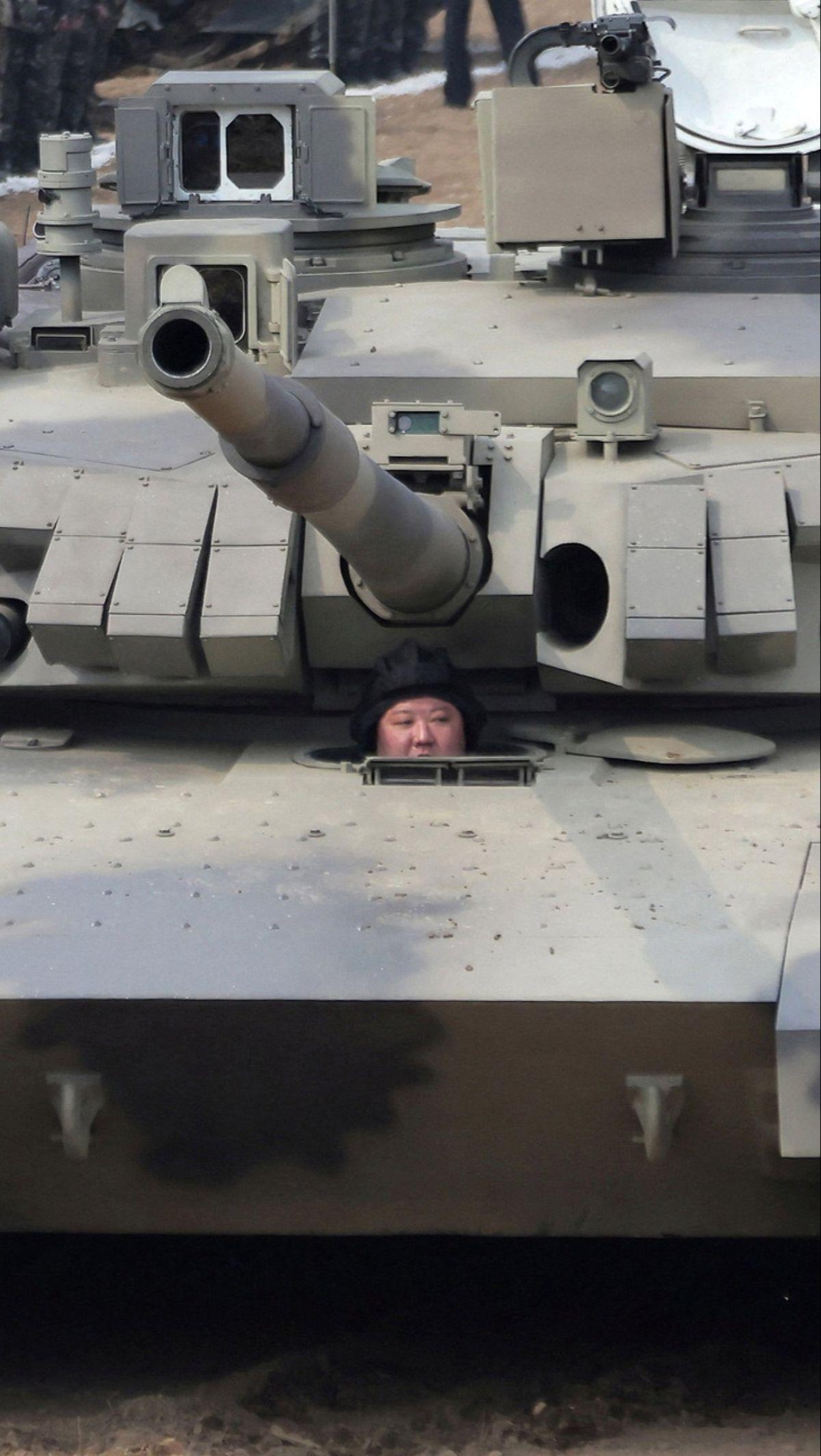 Dalam aksinya, Kim Jong-un terlihat berada di bawah moncong tank. Dia tampak memakai pelindung kepala khusus. Gayanya bak serdadu perang.&nbsp;Foto: KCNA via REUTERS