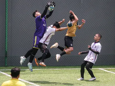 Kiper tim Golden Boutique (kiri) berusaha menangkap bola saat melawan tim Artotel pada turnamen Asatu Hoteliers Cup 2023 yang berlangsung di Asatu Area, Menteng, Jakarta, Minggu (29/10/2023). (Bola.com/Bagaskara Lazuardi)