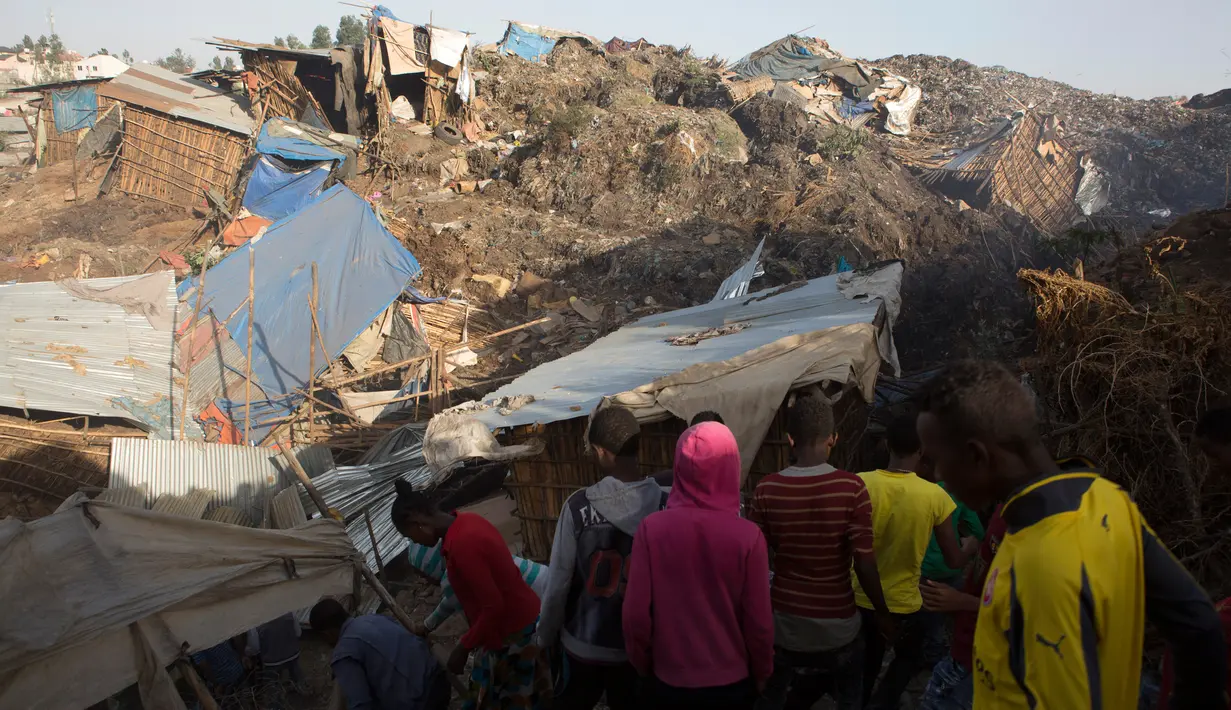 Sejumlah orang melihat kerusakan akibat longsoran sampah di tempat pembuangan akhir (TPA) luar ibu kota Ethiopia, Addis Ababa, Minggu (12/3). Sebagian besar korban ialah para penduduk sekitar yang bekerja sebagai pemulung di TPA. (Zacharias ABUBEKER/AFP)