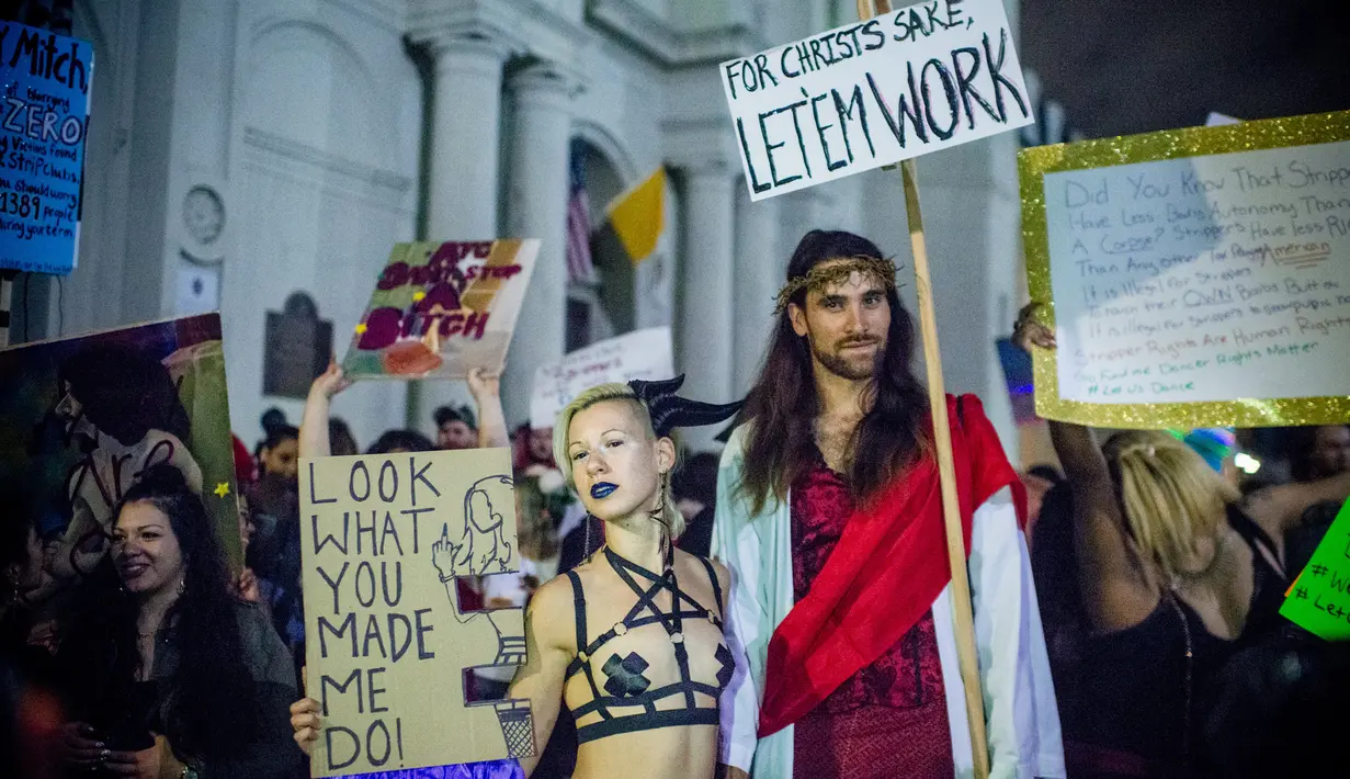 Sejumlah orang membawa poster melakukan demonstrasi di Bourbon Street, New Orleans (1/2). Aksi demonstrasi ini dilakukan oleh para penari, pekerja klub malam dan pendukungnya. (AFP/Emily Kask)