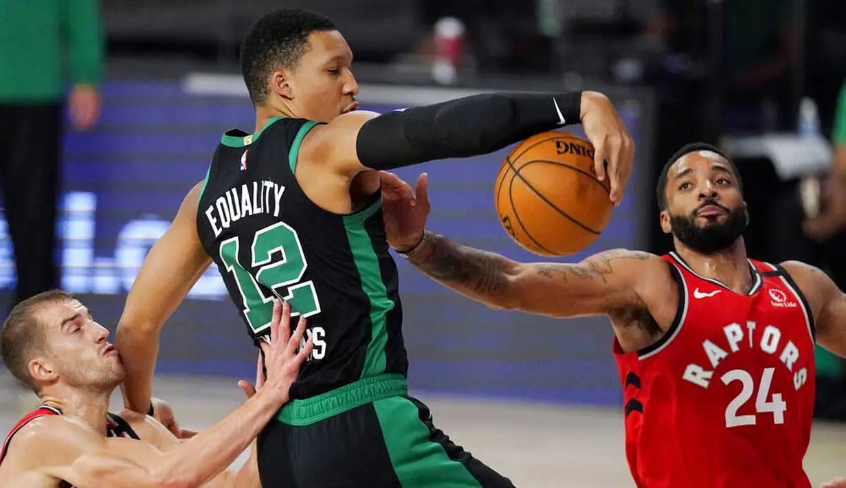 Pebasket Boston Celtics, Grant Williams, berebut bola dengan pebasket Toronto Raptors, Norman Powell, pada laga NBA di Lake Buena Vista, Senin (7/9/2020). Boston Celtics menang telak 111-89 atas Toronto Raptors. (AP/Mark J. Terrill)