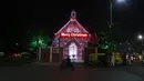Seorang pengendara skuter melewati Gereja yang diterangi lampu pada malam Natal di Ahmedabad, India, Jumat (24/12/2021). (AP Photo/Ajit Solanki)