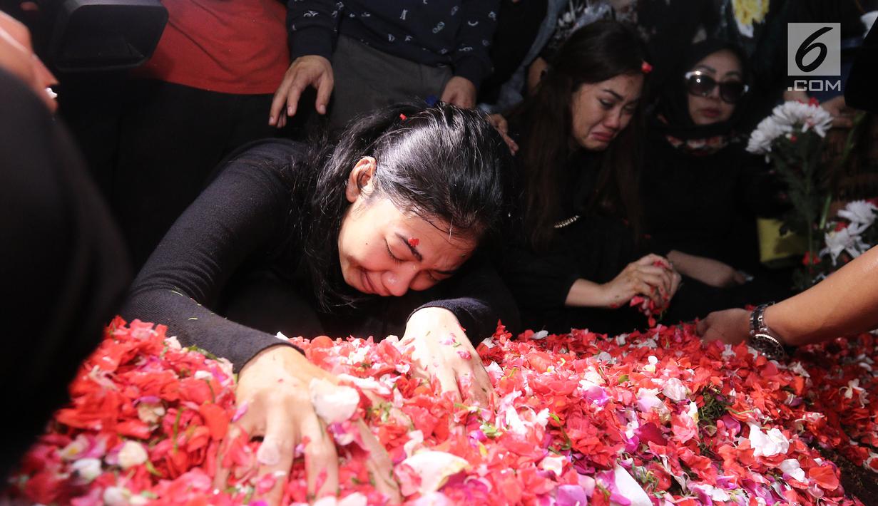 Adik Julia Perez, Della Perez menangis di samping makam Julia Perez di di TPU Pondok Ranggon, Jakarta, Sabtu (10/6). Jupe diketahui mengidap sakit kanker serviks sejak 2014 silam. (Liputan6.com/Herman Zakharia)