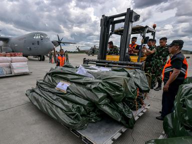 Personel TNI Angkatan Udara dan petugas Badan Nasional Penanggulangan Bencana (BNPB) bersiap memasukkan bantuan kemanusiaan dari pemerintah Indonesia untuk korban gempa bumi di Myanmar ke dalam pesawat angkut Hercules C-130 di Pangkalan Udara Halim Perdanakusuma, Jakarta, 31 Maret 2025. (BAY ISMOYO/AFP)