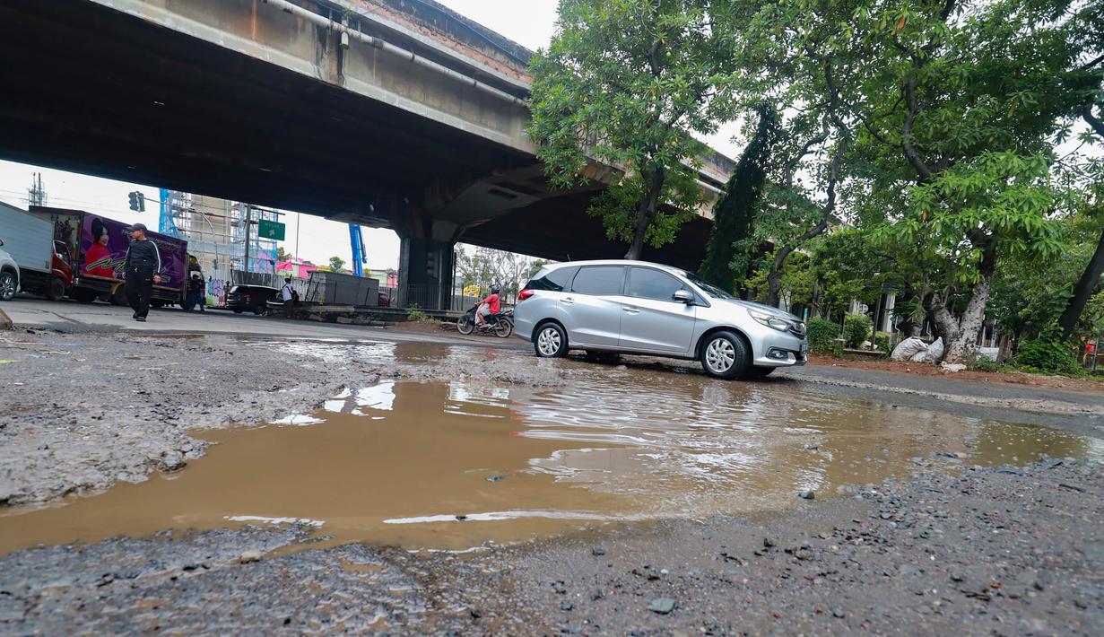 Kerusakan terlihat di sejumlah titik berupa lubang yang mengganggu kelancaran lalu lintas. Tampak dalam foto, sejumlah pengendara melewati jalan rusak di Jalan Gedong Panjang, Penjaringan Jakarta Utara, Selasa (3/2/2026). (merdeka.com/Arie Basuki)
