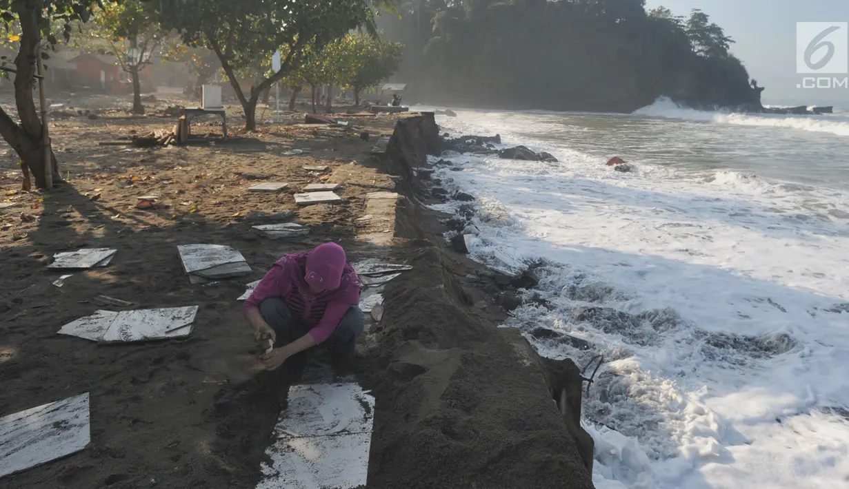 Warga mengambil sisa keramik dari bangunan yang hancur diterjang ombak di Karanghawu, Pelabuhan Ratu, Sukabumi, Minggu (29/7). Gelombang pasang juga menyebabkan abrasi karena tanggul penahan ombak yang dibuat warga rusak berat. (Merdeka.com/Arie Basuki)