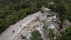 Rumah-rumah tergeletak di reruntuhan di sepanjang jalan yang rusak, empat hari setelah gempa berkekuatan 7,2 melanda bagian barat daya negara itu, di Rampe, Haiti, Rabu (18/8/2021). Korban jiwa akibat gempa di Haiti Sabtu pekan lalu terus bertambah menjadi 1.941 orang. (AP/Matias Delacroix)