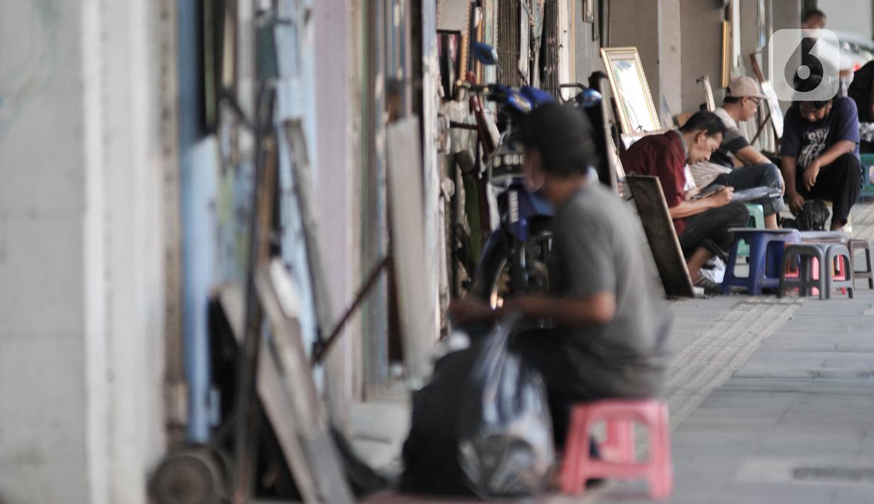 Seniman lukis menyelesaikan karyanya di pinggir Jalan Pintu Besar Selatan, Pinangsia, Jakarta, Selasa (2/6/2020). Sejumlah seniman memilih tutup sementara di tengah pandemi virus corona COVID-19, sedangkan beberapa lainnya tetap bertahan demi mendapatkan penghasilan. (merdeka.com/Iqbal S. Nugroho)