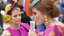 Seorang wanita minum sebelum pertandingan pacuan kuda Piala Melbourne di Melbourne (5/11/2019). Para wanita tampil cantik dan modis dengan hiasan kepala yang mereka gunakan selama menyaksikan balap kuda di Melbourne Cup.  (AFP Photo/William West)