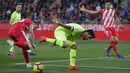 Striker Barcelona, Luis Suarez, berebut bola dengan pemain Girona, Borja Garcia, pada laga La Liga di Stadion Montilivi, Minggu (27/1). Barcelona menang 2-0 atas Girona. (AP/Manu Fernandez)