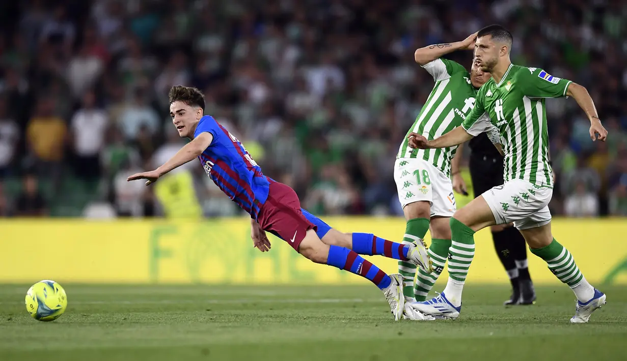 <p>Pemain Barcelona Gavi (kiri) berebut bola dengan pemain Real Betis Guido Rodriguez (kanan) pada pertandingan sepak bola La Liga Spanyol di Stadion Benito Villamarin, Seville, Spanyol, 7 Mei 2022. Barcelona menang 2-1. (AP Photo/Jose Breton)</p>
