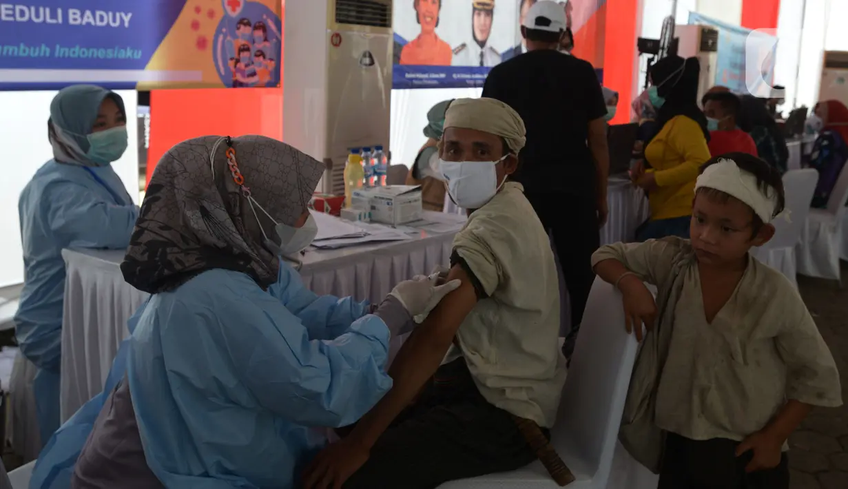 Tim medis memberikan vaksin Covid-19 kepada seorang masyarakat Baduy di Desa Kanekes, Ciboleger, Kabupaten Lebak, Banten Kamis (14/10/2021). Tujuan vaksinasi Covid-19 untuk mempercepat kekebalan komunal (Herd imunity) mencegah penyebaran virus corona. (merdeka.com/Imam Buhori)