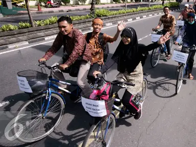 Sejumlah mahasiswa UGM berbusana batik saat pawai sepeda di kawasan Kridosono Yogyakarta, Minggu (2/10). Kegiatan tersebut untuk memperingati Hari Batik Nasional. (Liputan6.com/Boy Harjanto)