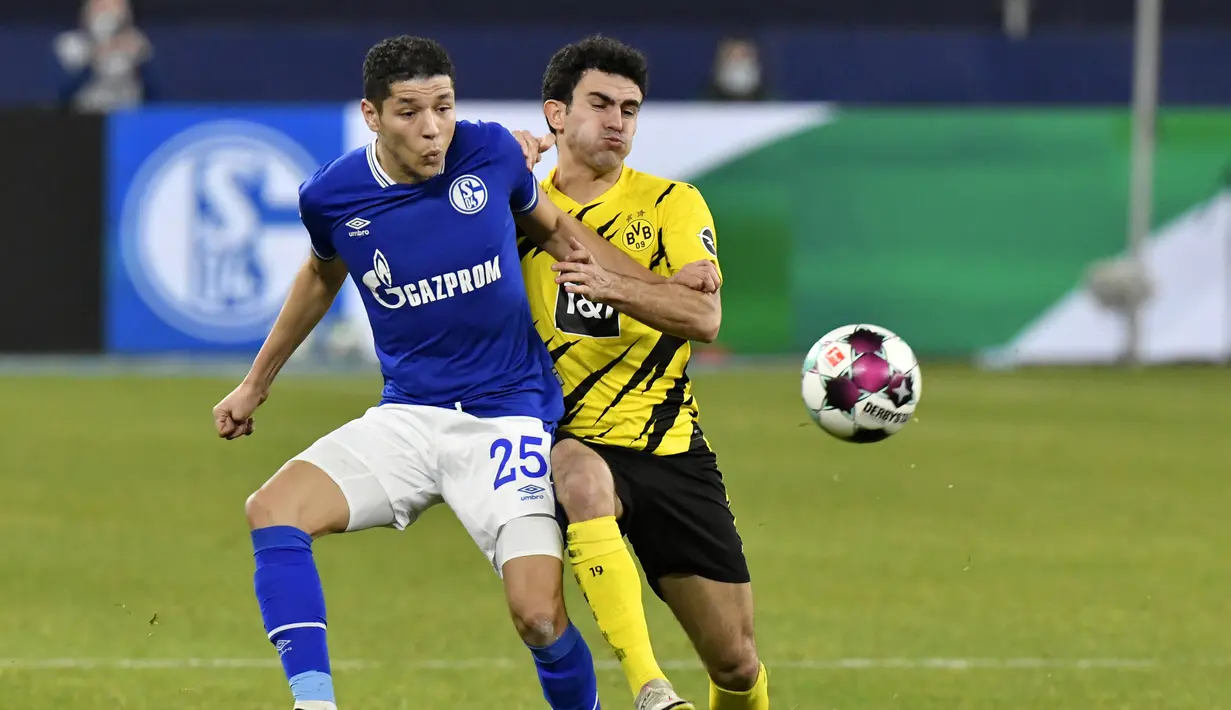 Gelandang Schalke, Amine Harit (kiri) berebut bola dengan bek Borussia Dortmund, Mateu Morey dalam laga lanjutan Liga Jerman 2020/21 pekan ke-22 di Veltins Arena, Sabtu (20/2/2021). Schalke kalah 0-4 dari Borussia Dortmund. (AP/Martin Meissner/Pool)