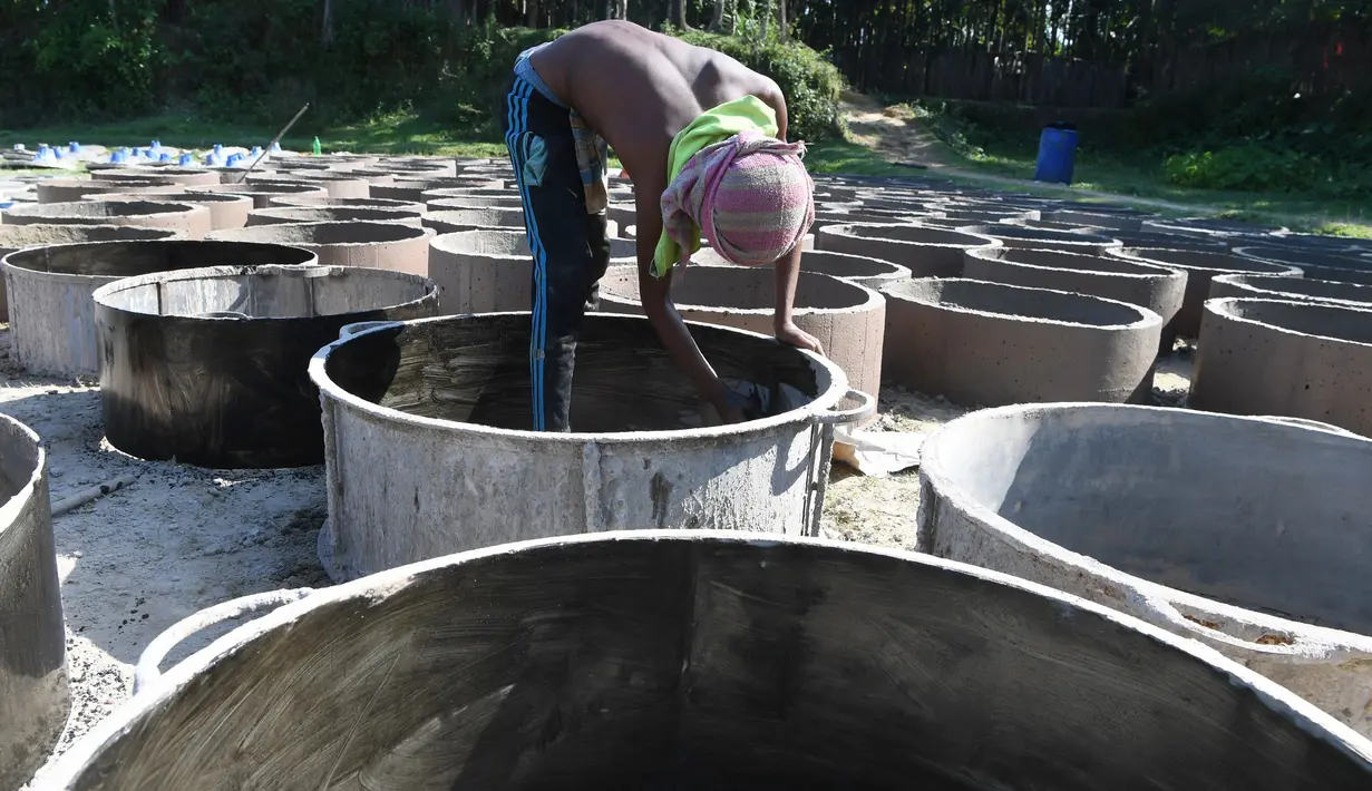 Bocah laki-laki Bangladesh menyelesaikan pembuatan toilet untuk pengungsi Rohingya di Sonarpara, Cox's Bazar, Rabu (11/10). Gelombang besar masuknya pengungsi Rohingya ke Bangladesh menyebabkan melonjaknya permintaan akan toilet. (INDRANIL MUKHERJEE/AFP)