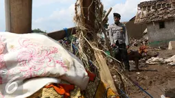 Petugas bersama annjing pelacak K-9 dari Polda Jawa Barat menyisir reruntuhan bangunan rumah akibat banjir bandang di Kampung Bojong Sudika, Cimacan, Garut, Jumat (23/9). (Liputan6.com/Johan Tallo)