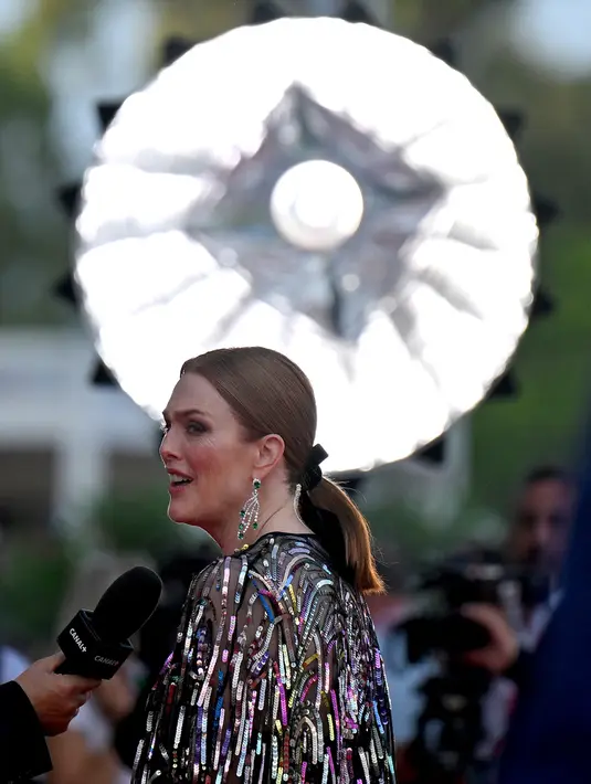 Aktris Amerika Serikat sekaligus Presiden Juri Venice Film Festival 2022 Julianne Moore tiba untuk upacara pembukaan dan pemutaran film "White Noise" di Venesia, Italia, Rabu (31/8/2022). Meningkatkan tinggi badannya, Julianne menambahkan sepasang sepatu hak hitam saat berjalan mondar-mandir melewati karpet merah untuk kamera. (Tiziana FABI/AFP)