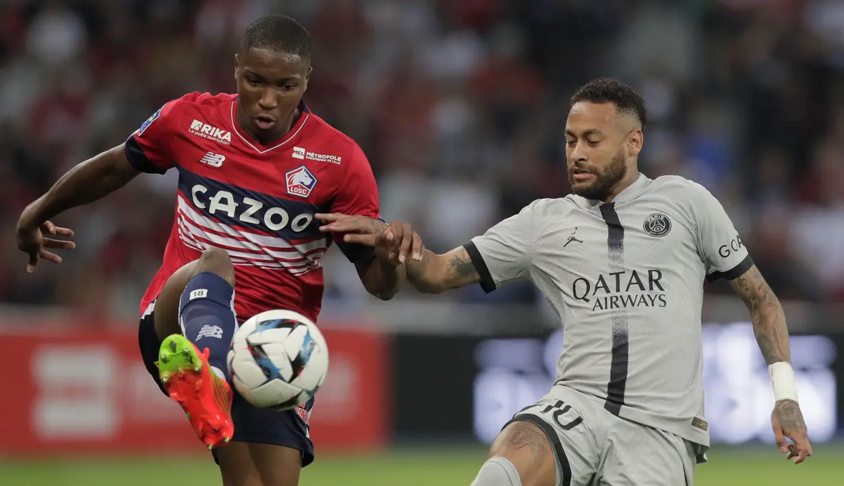 Penyerang Paris Saint-Germain (PSG) Neymar berebut bola dengan bek Lille Bafode Diakite pada pekan ketiga Ligue 1 (Liga Prancis) 2022/2023  di Stadion Pierre-Mauroy, Senin (22/8/2022) dini hari WIB.  PSG berpesta gol ke gawang Lille dengan skor 7-1. (AP Photo/Michel Spingler)