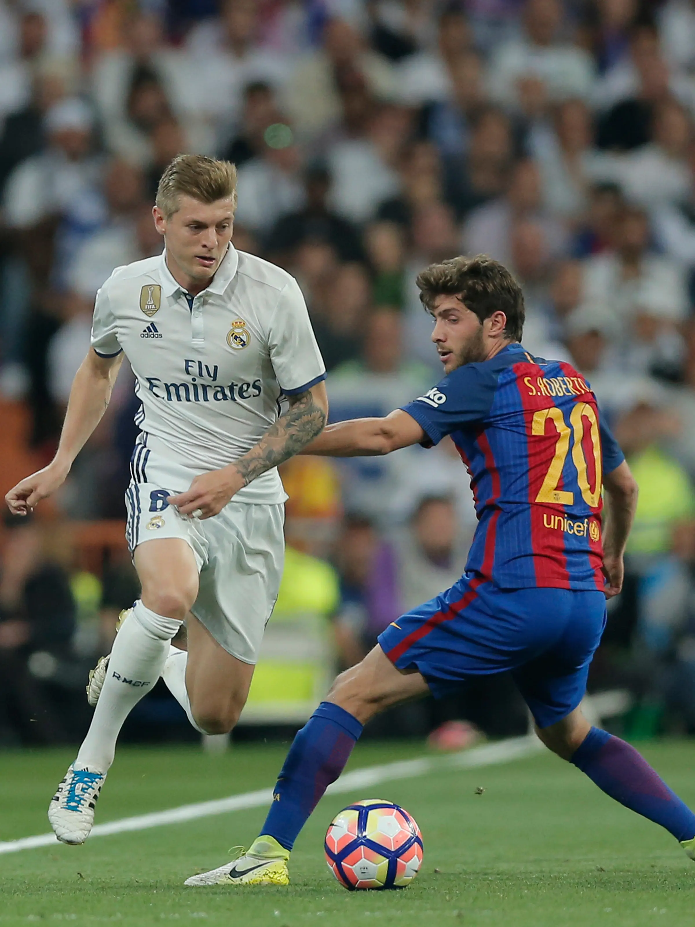 Gelandang Real Madrid, Toni Kroos berusaha melewati gelandang Barcelona, Sergi Roberto. (AP Photo/Daniel Ochoa de Olza)