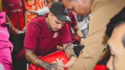 Shayne Pattynama menandatangani jersey milik Jakmania dalam acara meet & greet di Kantor Pusat Bank Jakarta pada Rabu (18/2/2025). (Bola.com/Nur Iman Ali)