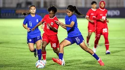 Pemain Timnas Putri Indonesia, Marcela Awi, berusaha melewati pemain Singapura dalam laga uji coba di Stadion Madya, Senayan, Jakarta, Selasa, (28/5/2024). (Bola.com/Bagaskara Lazuardi)