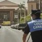 Seorang petugas polisi berdiri di depan hotel H10 Costa Adeje Palace di mana sebuah ambulans diparkir di Tenerife, Canary Island, Spanyol, Selasa, (25/2/2020). Hotel ini diisolasi setelah salah satu kliennya, turis Italia, dinyatakan positif mengalami kontraksi dengan virus corona. (AP Photo)