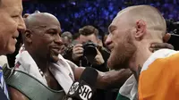 Floyd Mayweather Jr berbicara dengan Conor McGregor setelah bertarung selama 10 ronde di T-Mobile Arena, Las Vegas, Sabtu (26/8/2017) atau Minggu (27/8/2017) WIB. (AP Photo/Isaac Brekken)