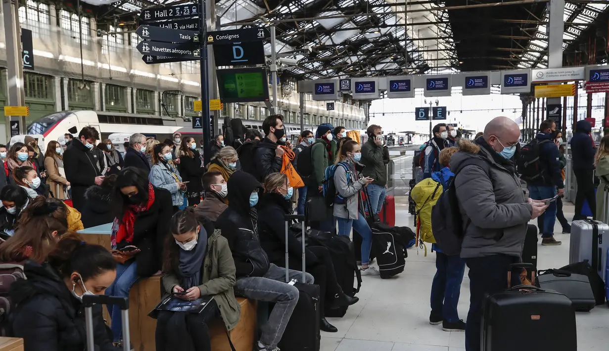 Orang-orang yang memakai masker menunggu dengan barang bawaan mereka di stasiun kereta Gare de Lyon di Paris, Jumat (19/3/2021). Prancis menerapkan karantina wilayah di Paris dan beberapa daerah lain di bagian utara selama sebulan dan dimulai pada Jumat tengah malam. (AP Photo/Michel Euler)