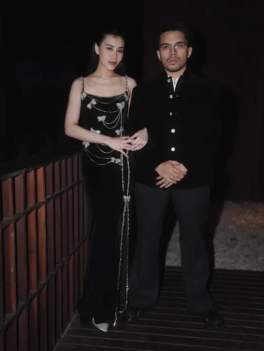 Aaliyah Massaid hadir bersama suami, Thoriq Halilintar yang kompak pakai baju hitam. Aaliyah elegan dibalut long dress spaggeti strap dihiasi bros kupu-kupu. Thoriq Halilintar mengenakan atasan hitam. [@aaliyah.massaid]