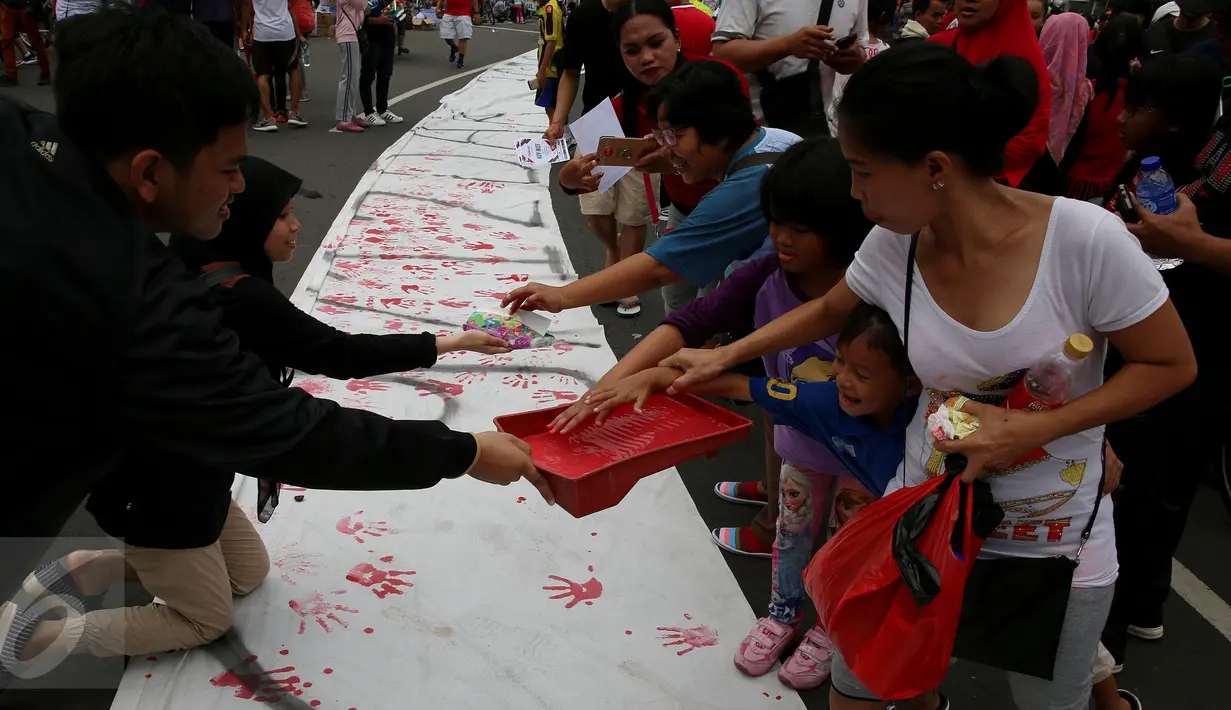 Aksi jelang peringatan Hari Anti Korupsi Sedunia  9 Desember  yang dilakukan BEM UI ini mengajak warga untuk berpartisipasi dalam gerakan nasional memberantas korupsi, Jakarta, Minggu (27/11). (Liputan6.com/Johan Tallo) 
