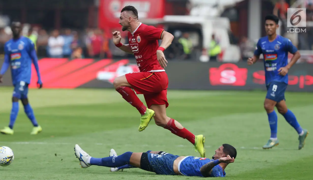Pemain depan Persija, Marko Simic melompat menghindari tekel pemain Arema FC pada lanjutan Shopee Liga 1 Indonesia 2019 di Stadion Gelora Bung Karno, Jakarta, Sabtu (3/8/2019). Laga berakhir imbang 2-2. (Liputan6.com/Helmi Fithriansyah)
