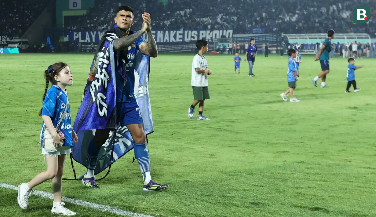 Pemain Persib Bandung, Ciro Alves berjalan dengan putrinya saat merayakan merayakan kemenangan atas Madura United pada laga leg 1 final Championship Series BRI Liga 1 2023/2024 di Stadion Si Jalak Harupat, Bandung, Minggu (26/05/2024). (Bola.com/M Iqbal Ichsan)