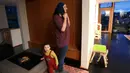 Nadia Chaouch mengenakan jilbab dalam persiapan untuk salat ketika putranya Yusuf Kamel berjalan melewati setelah keluarga berbuka puasa pada bulan sucir Ramadan di rumah mereka selama wabah coronavirus di Seattle (28/4/2020). (AP/Elaine Thompson)