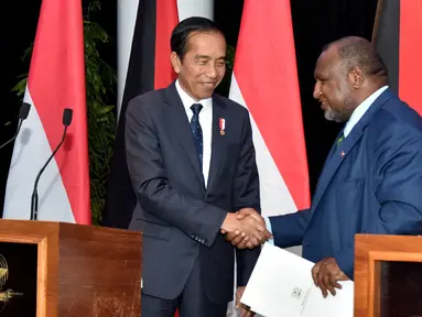 Presiden Indonesia Joko Widodo atau Jokowi (kiri) dan Perdana Menteri Papua Nugini James Marape (kanan) berjabat tangan pada konferensi pers setelah pertemuan bilateral di APEC Haus, Port Moresby, Papua Nugini, Rabu (5/7/2023). (ANDREW KUTAN/AFP)