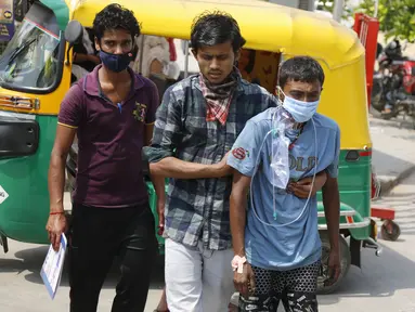 Kerabat tiba dengan pasien COVID-19 di rumah sakit pemerintah khusus COVID-19 di Ahmedabad, India, pada Selasa (27/4/2021). Kasus virus corona di India melonjak lebih cepat dari tempat lain di dunia. (AP Photo/Ajit Solanki)